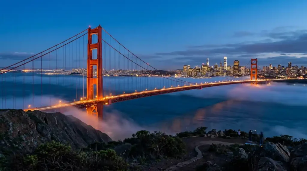Golden Gate Bridge San Francisco at blue hour with city skyline glowing and fog drifting beneath bridge towers