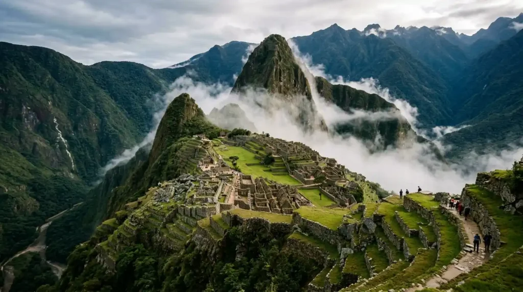 Machu Picchu Peru ancient Inca ruins on mountain ridge surrounded by misty green mountains and clouds